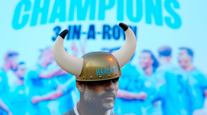 A figure of Pep Guardiola in front of a title banner.